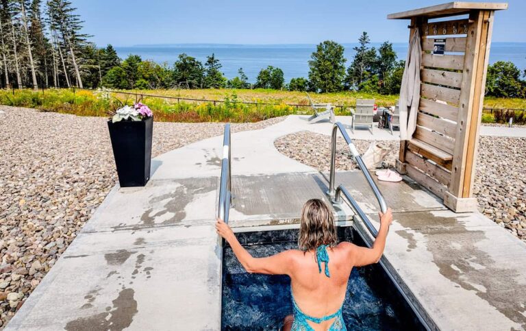 woman in nordic cold plunge pool overlooking bay of fundy at saltair spa